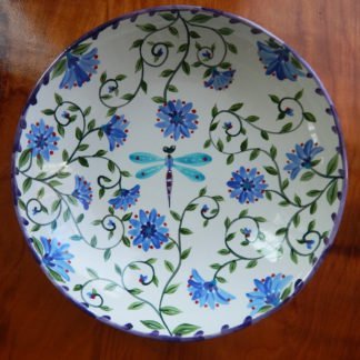 inside serving bowl with a colorful garden motif with a dragonfly