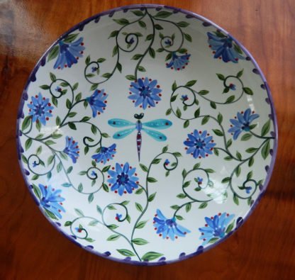 inside serving bowl with a colorful garden motif with a dragonfly