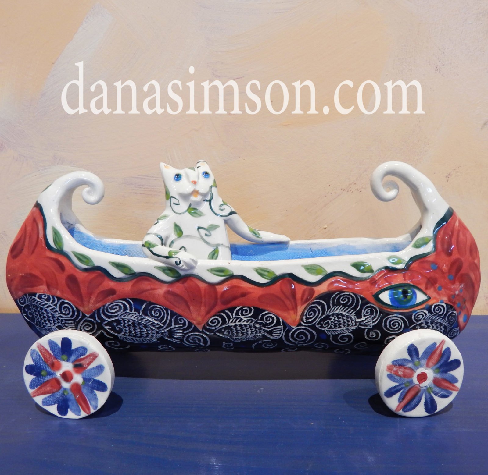 Danasimson.com Cat in canoe on wheels sculpture.