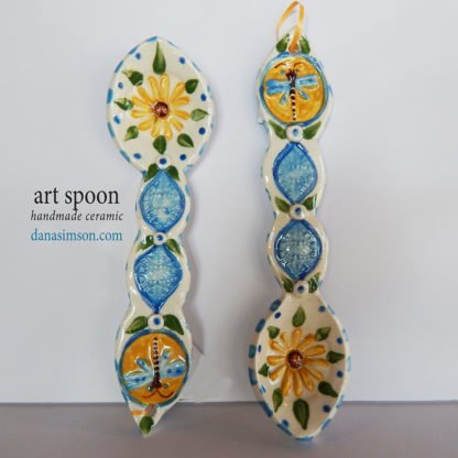 Danasimson.com handmade  folk art Dragonfly & Daisy Ceramic Spoon is cut out, formed in clay and individually decorated using my handmade stamps. The raised imagery detail includes a daisy in the spoon area and dragonfly on the handle.