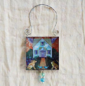 Danasmson.com Double sided beveled glass ornament with flying house image. Twisted wire handle and bead detail.