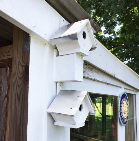 two fixed wooden birdhouses on a barn