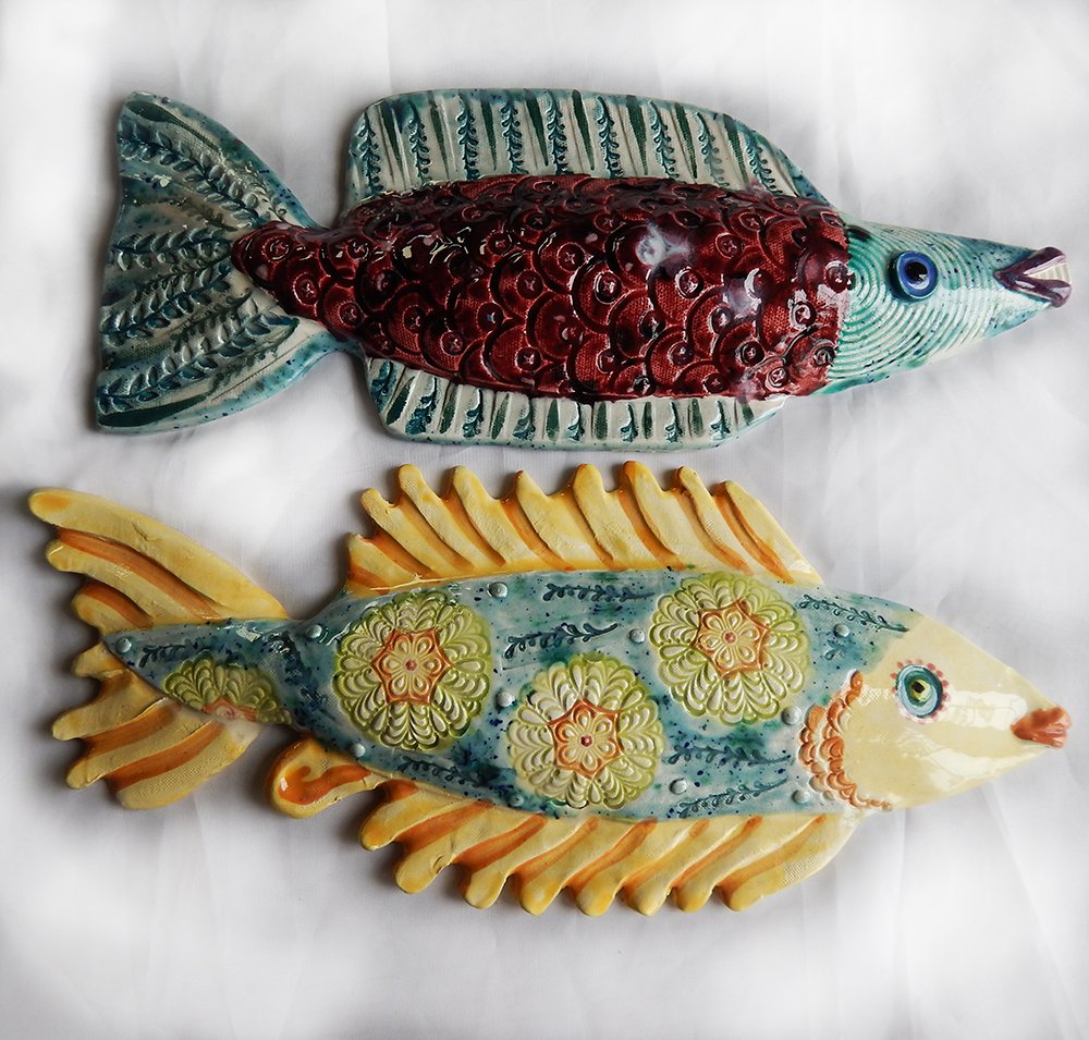 two intricately decorated ceramic fish