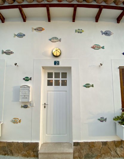 ceramic fish adorn the outside of a villa in Spain