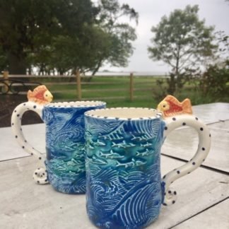 mugs with big tsunami waves and fish all over them